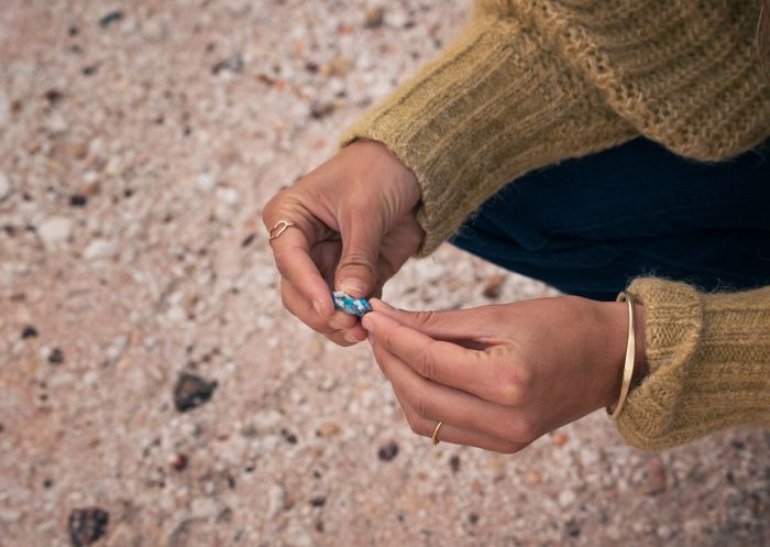 Woman holding an opal fragment at Grawin Opal Fields, Cumborah