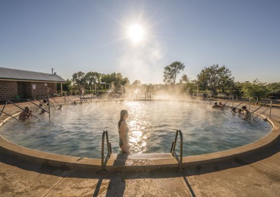 A woman steps into the steaming water at the Lightning Ridge Bore Baths, Lightning Ridge